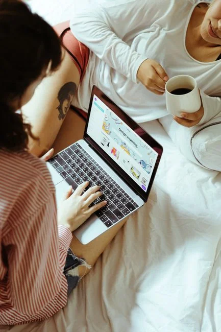 A modern workspace showing hands analyzing marketing data on a laptop and paper documents.
